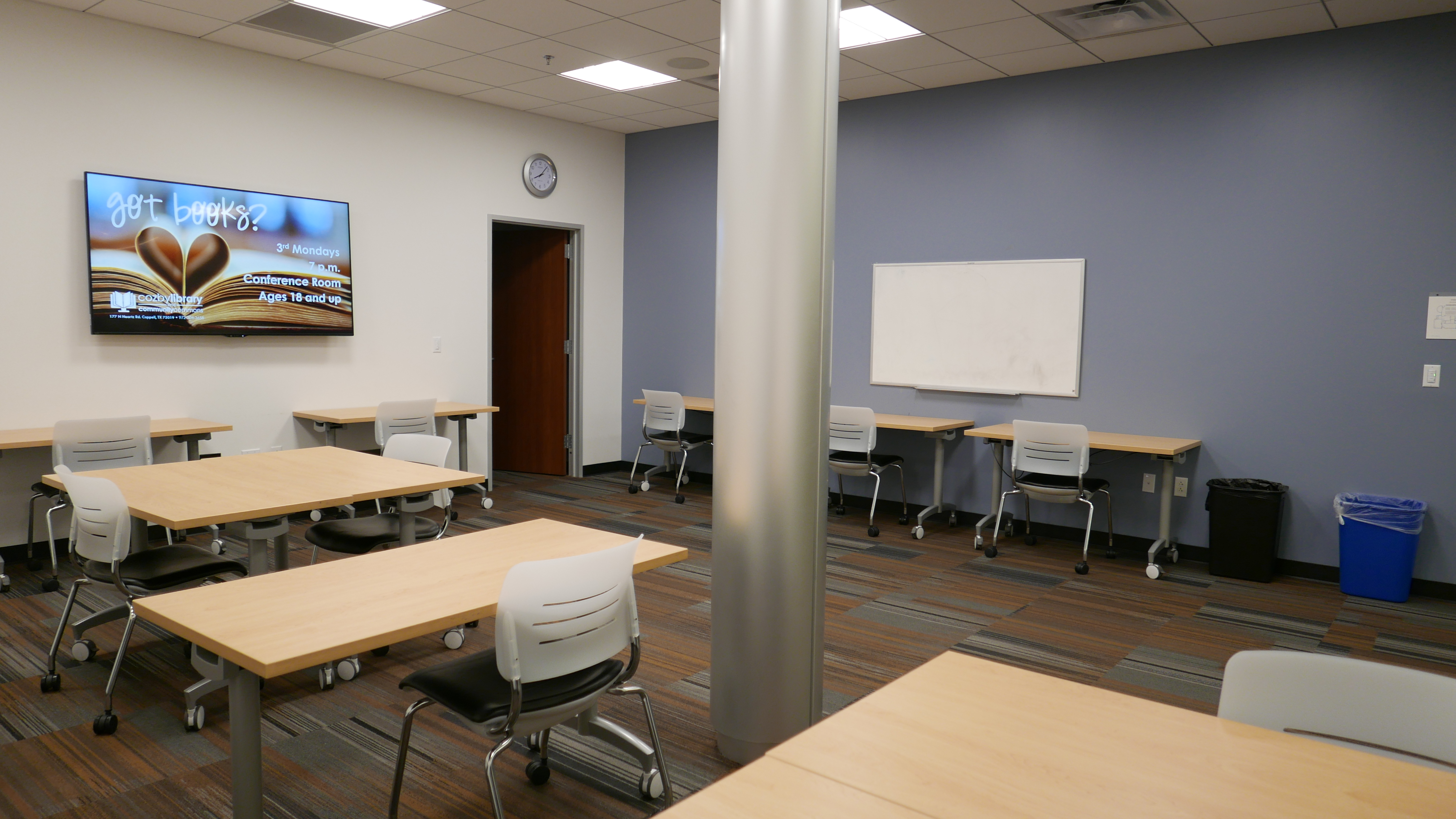 Business Center with various rectangular tables, chairs, white board, and mounted monitor