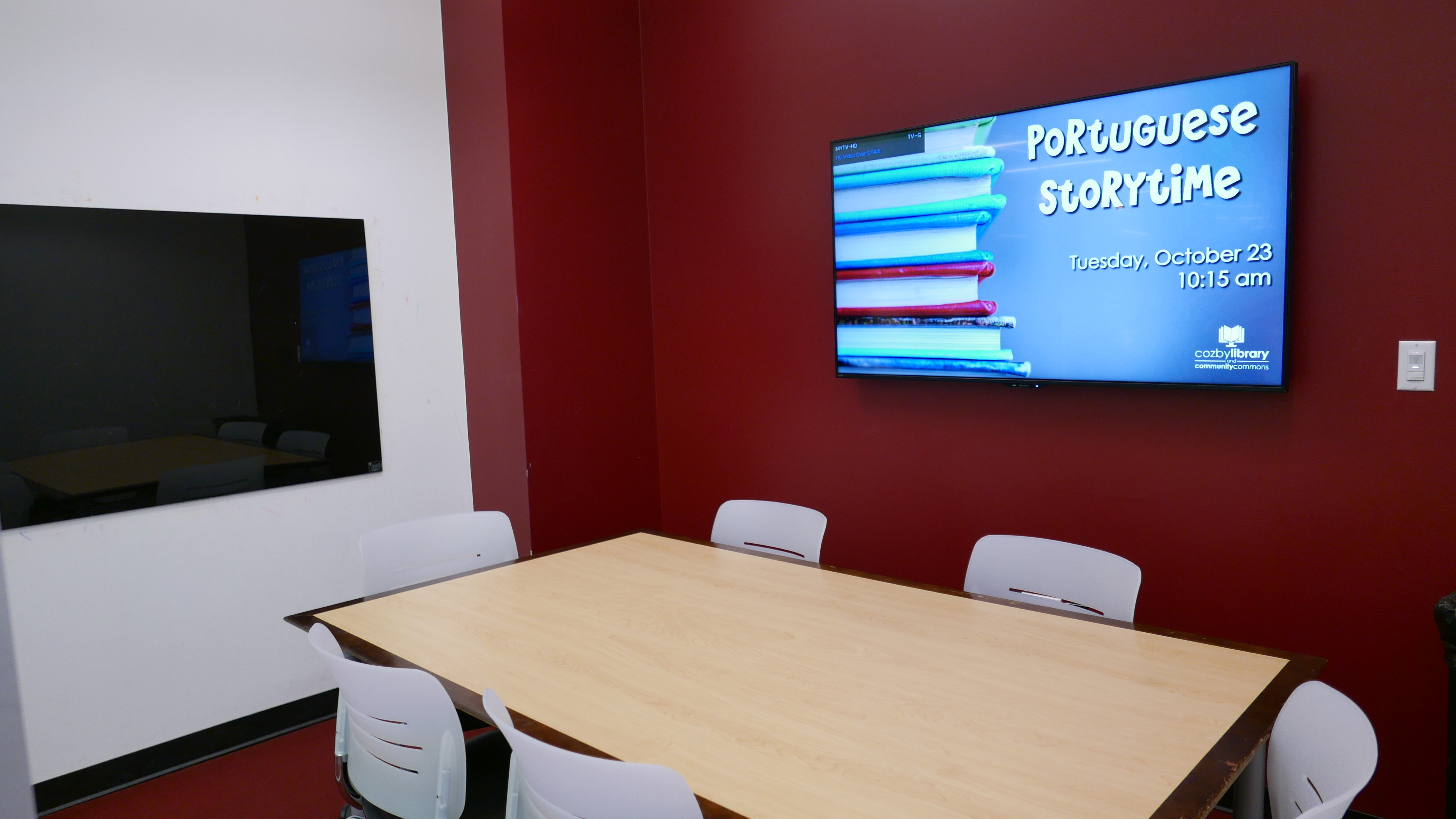 Study Room E equipped with rectangular table, 6 chairs, glass board, and mounted TV