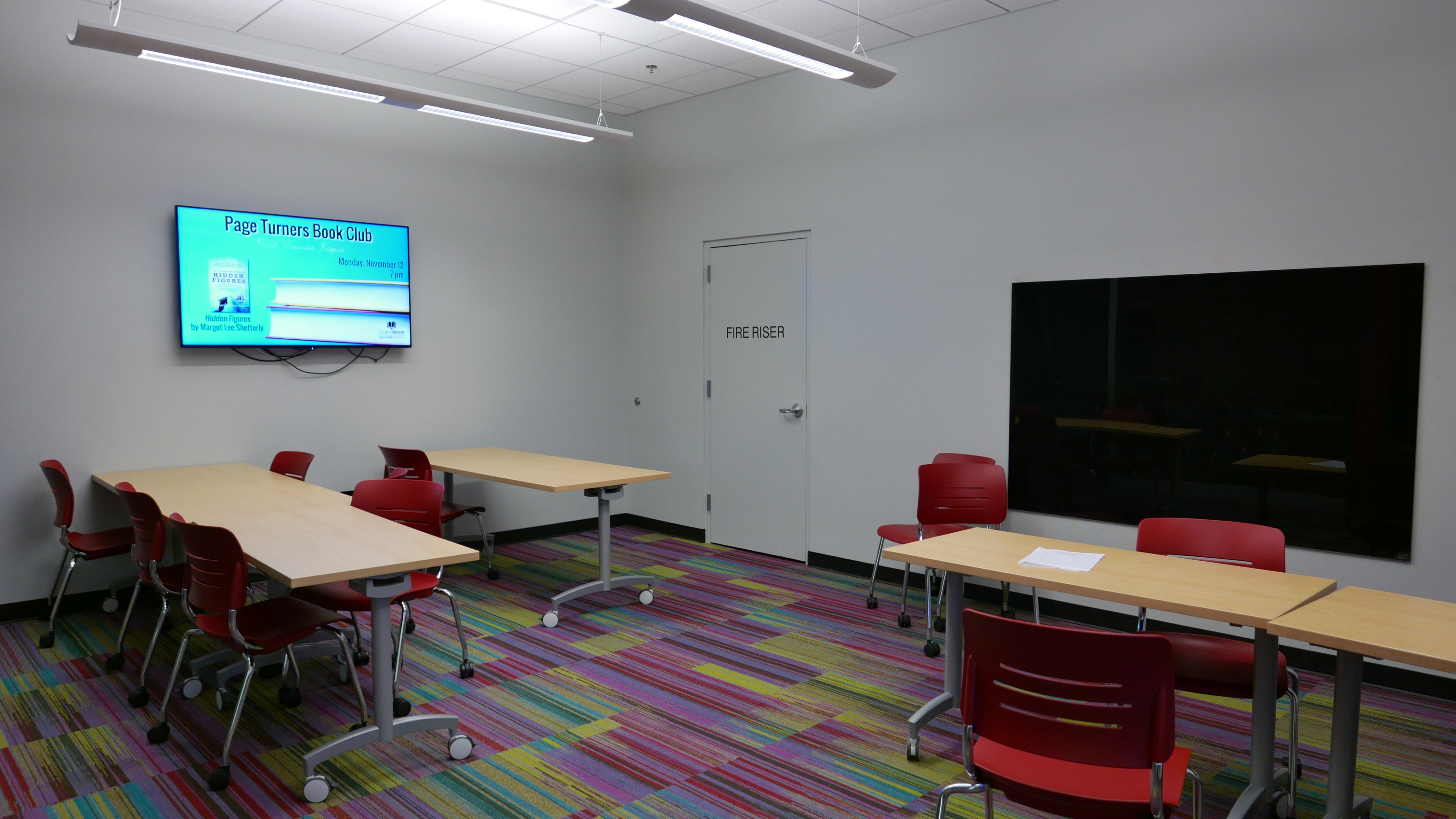 Study Room E with 5 tables, mounted television, and glass board