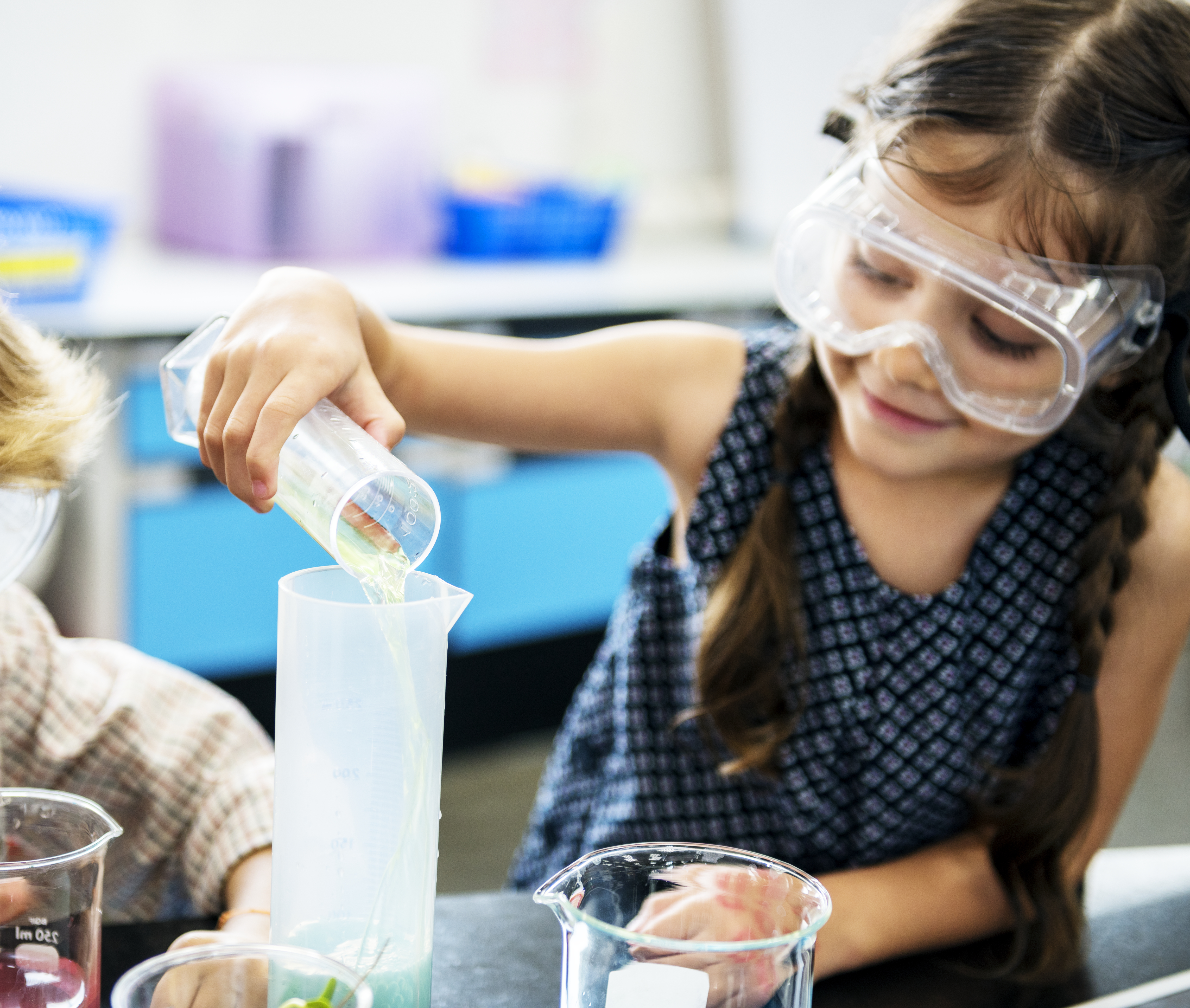 Girl wearing safety goggles doing science experiments.