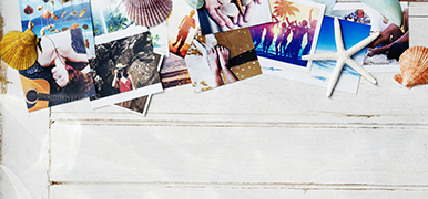 Various vacation photos and seashells on the top half of the picture. Photos are on a white wood background.