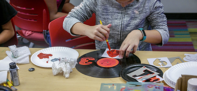 Teen painting on a vinyl record.