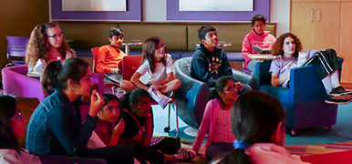 Teens sitting and watching a movie.