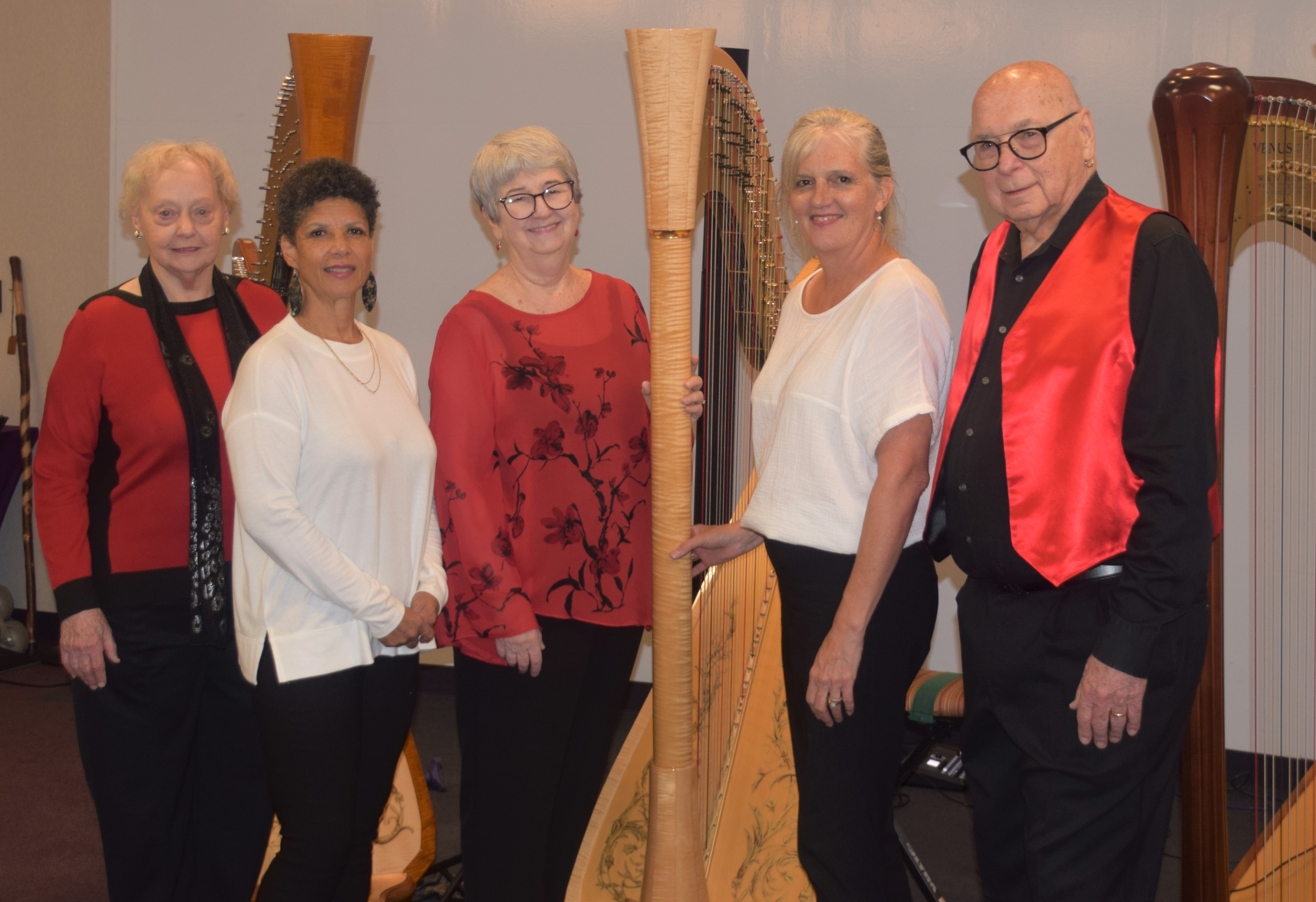 HarpEssence group members standing in front of a large harp
