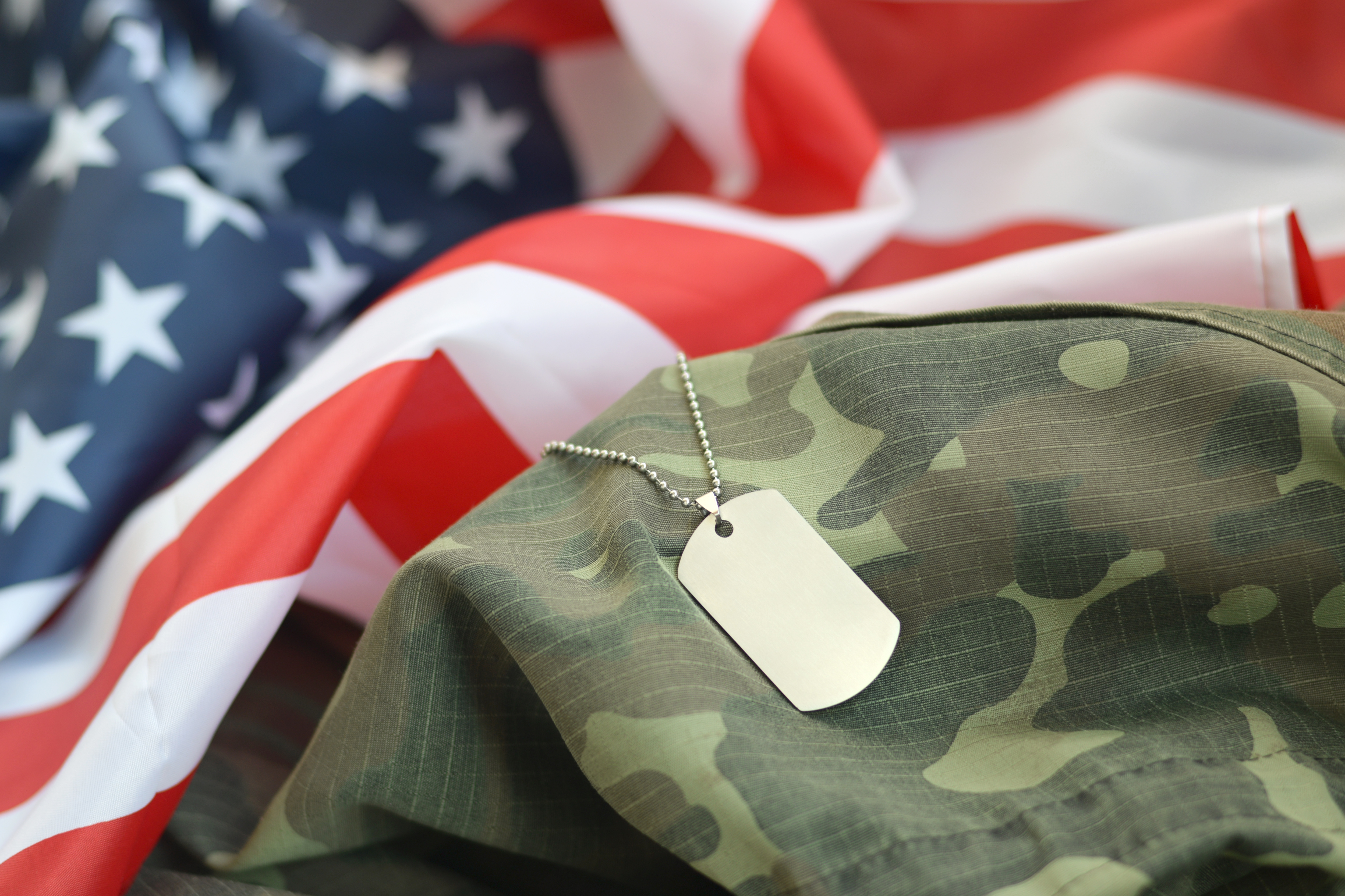 American flag with dog tag and camo uniform.