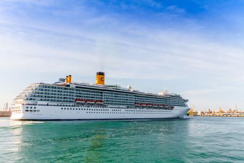 Cruise ship on the open water with a blue sky.