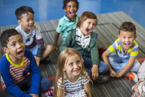 Kids sitting on the floor listening to a story.