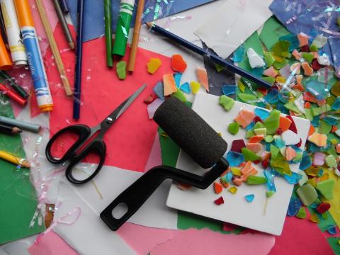 Various craft supplies including paper, scissors, a paint roller, and markers.