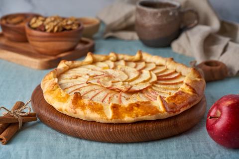 An apple galette on a wooden cutting board.