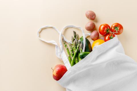 Various vegetables in a white canvas bag.