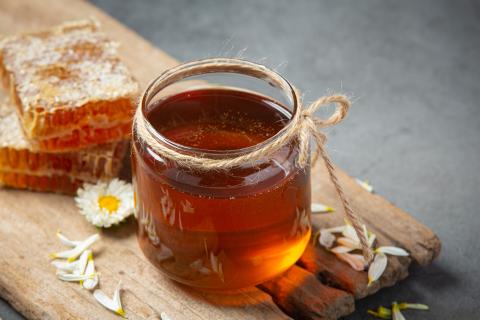 Glass of honey on a wooden table