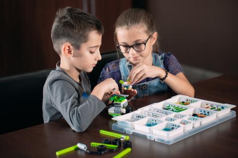 Two children playing with a robot