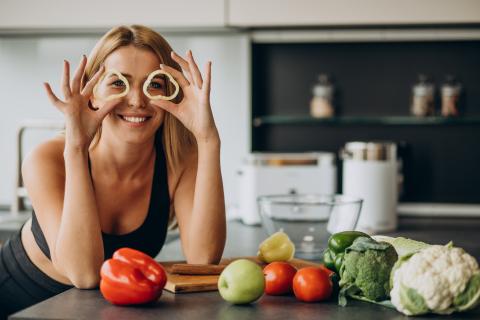 Young sporty woman with peppers in the kitchen