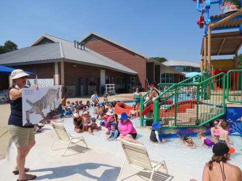 Storytime at the pool with kids and parents in the water.