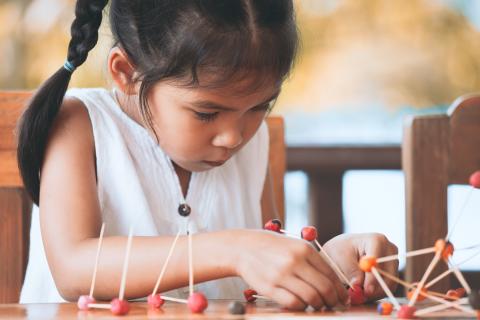 Young girl building with supplies.