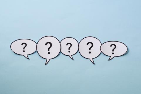 Question marks in paper speech bubbles on a blue background.