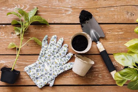 Gardening gloves and a shovel against wood table