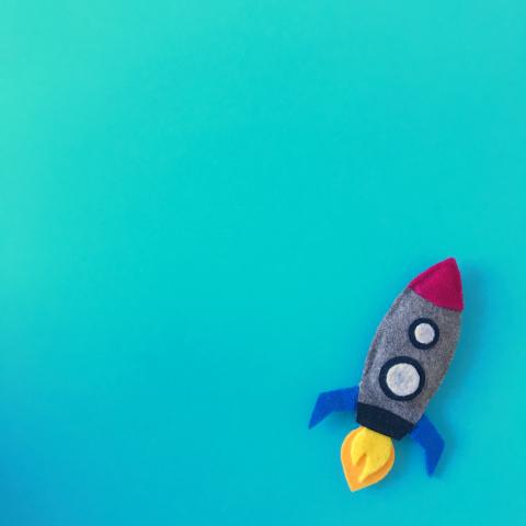 Felt rocket on blue background.