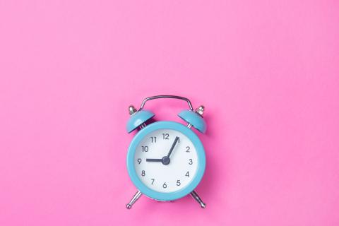 Alarm clock on a pink background.