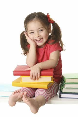 Smiling girl sitting with books on her lap. 