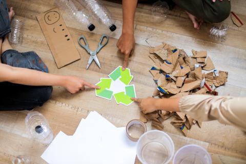 Hands pointing to a recycling symbol