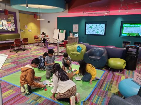 Teens sitting on the floor crafting.