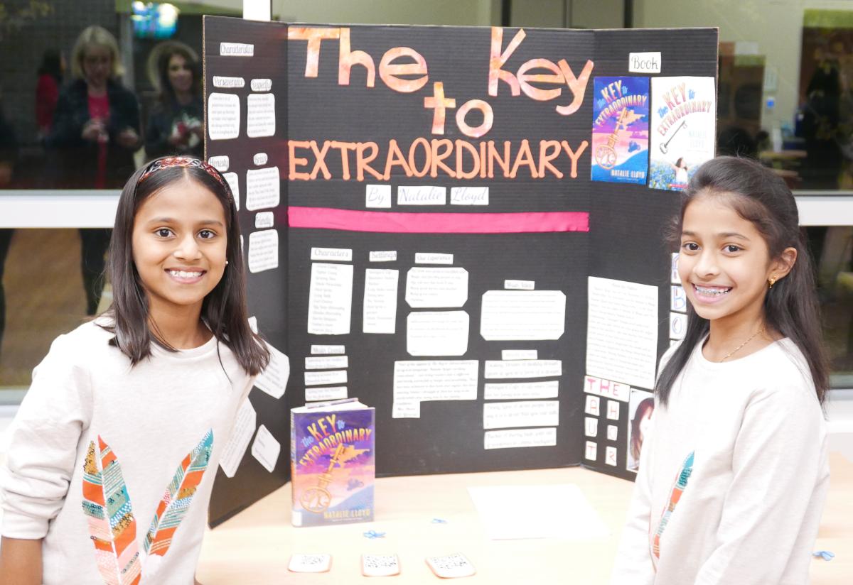 Two girls standing in front of a bluebonnet book display.