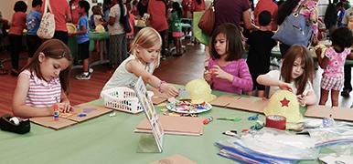 Several kids crafting with various art supplies.