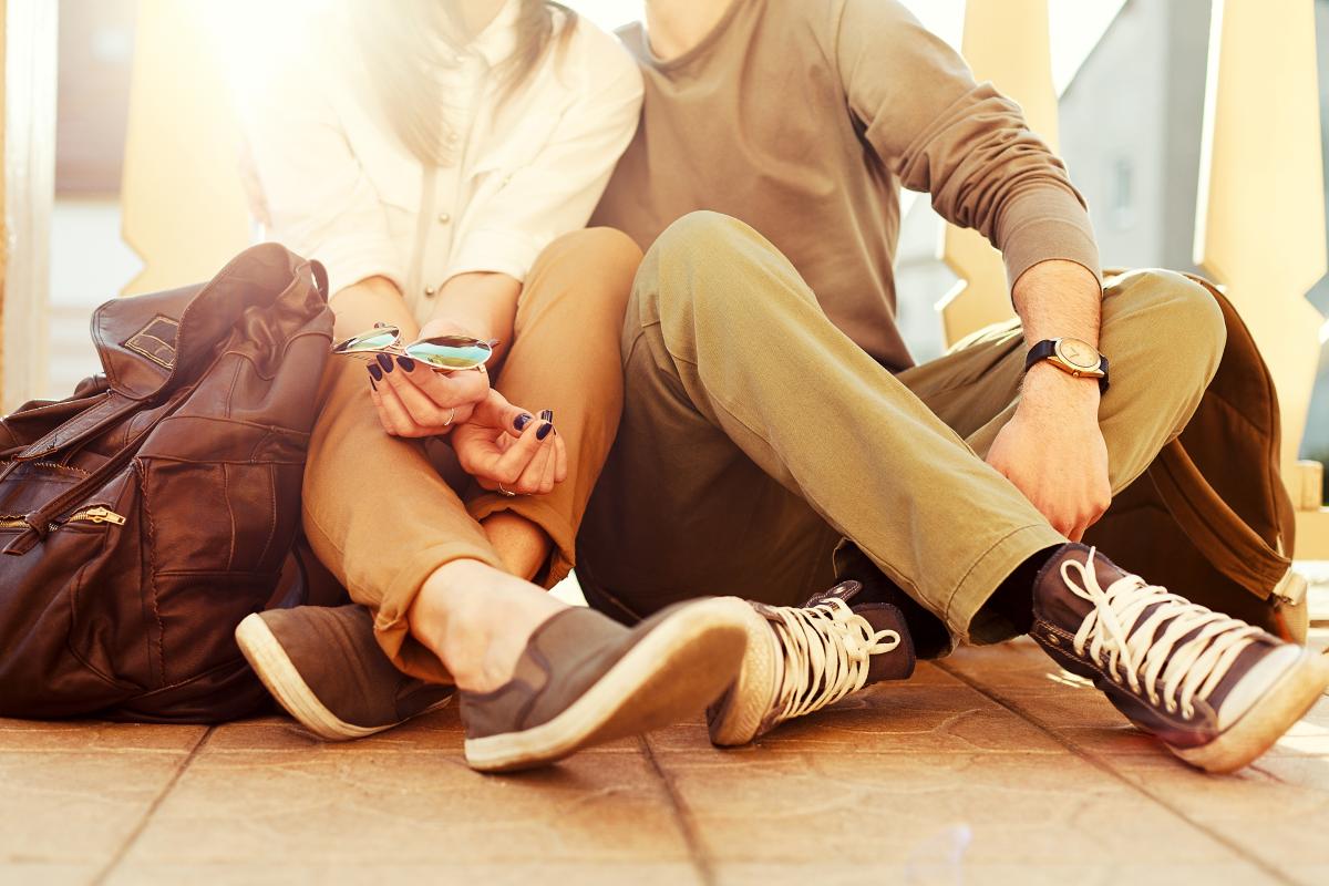 Couple sitting on the ground holding hands.