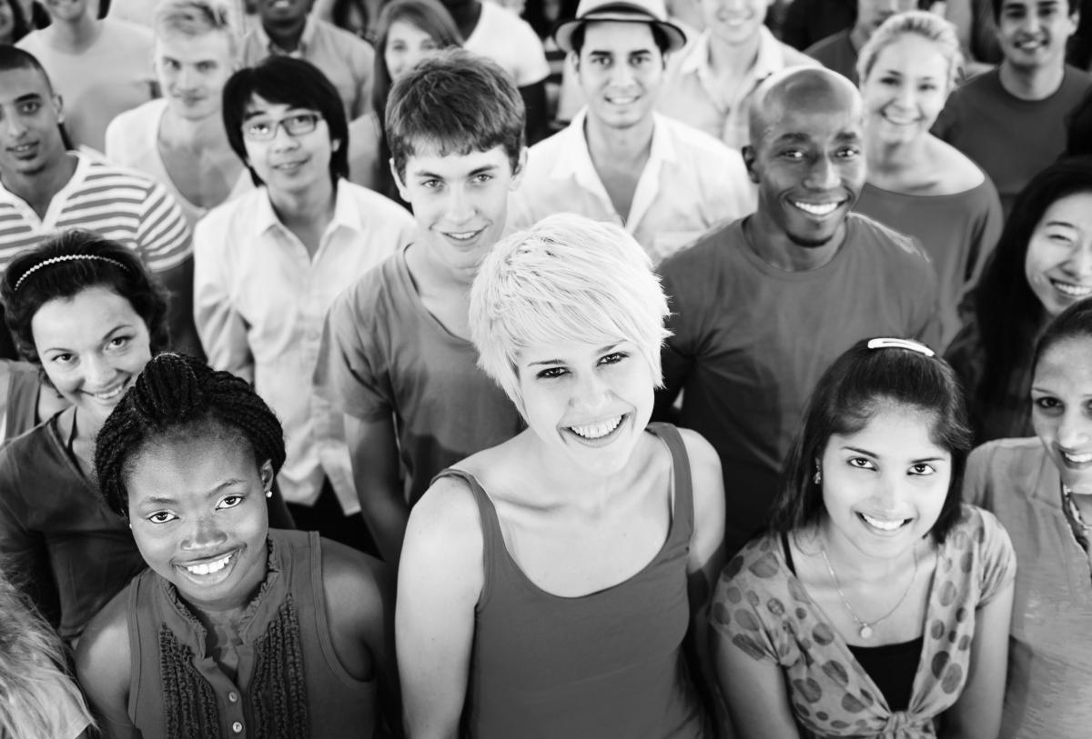 Large group of diverse people smiling at the camera. Black and white.