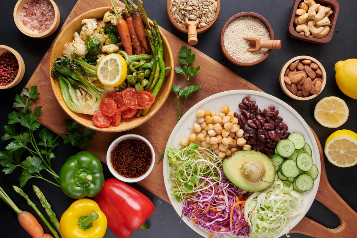 Bowls with vegetables and legumes on and around them