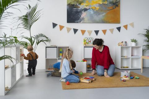 Adult watching children play with toys