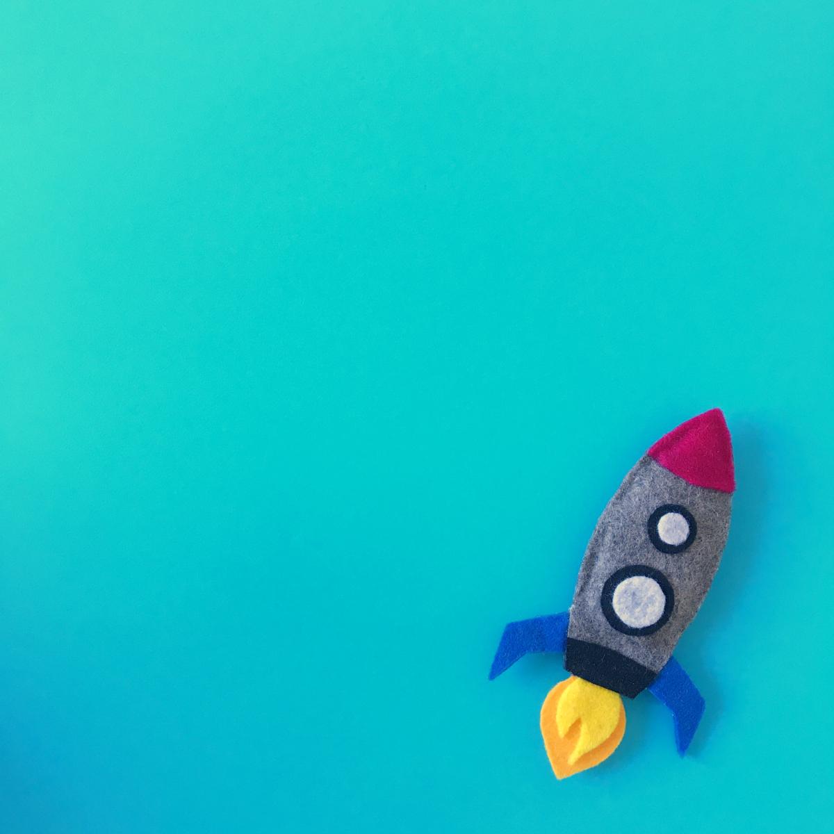 Felt rocket on blue background.