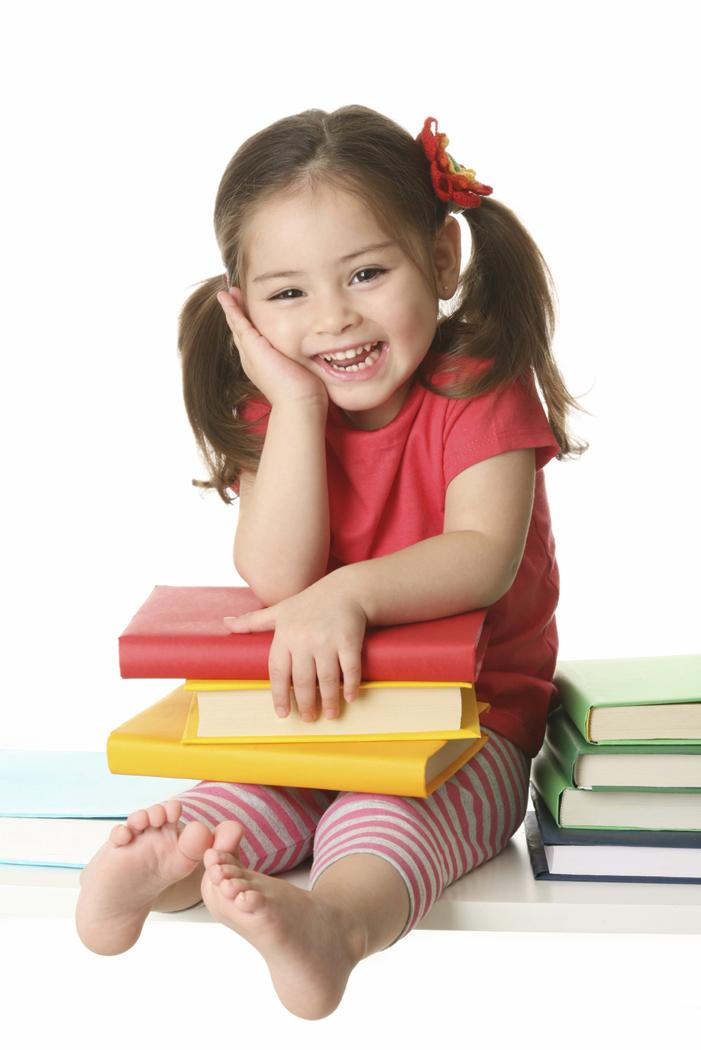 Smiling girl sitting with books on her lap. 