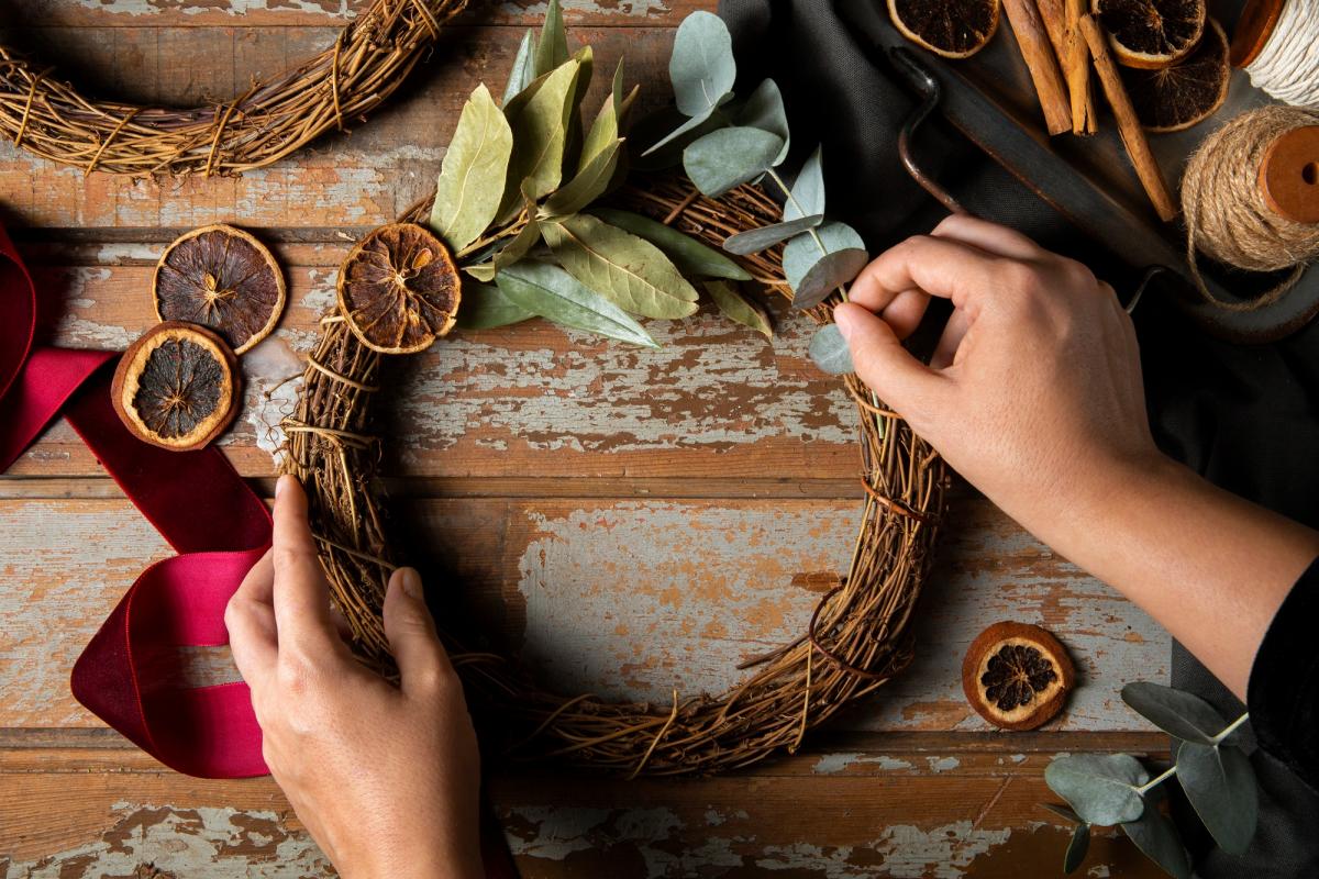 Hands decorating a wooden wreath